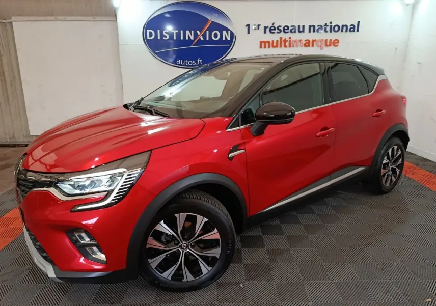 Renault Captur Techno TCe 90 rouge vue 3/4 avant droit en intérieur avec toit noir et jantes alliage.