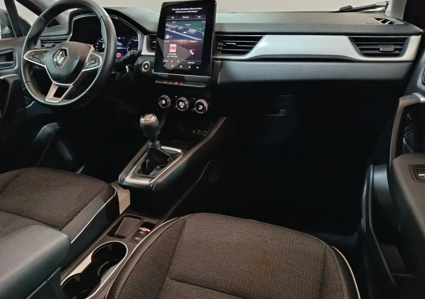 Intérieur noir du Renault Captur Techno TCe 90 2024, vue côté conducteur avec écran tactile vertical et boîte manuelle.