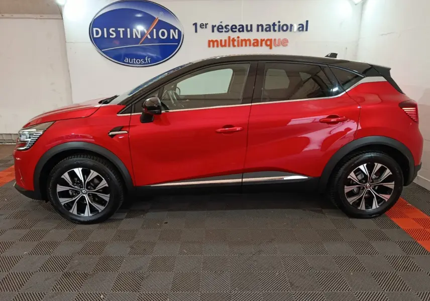 Profil droit d'un Renault Captur Techno TCe 90 rouge 2024 avec toit noir et jantes alliage bicolores.