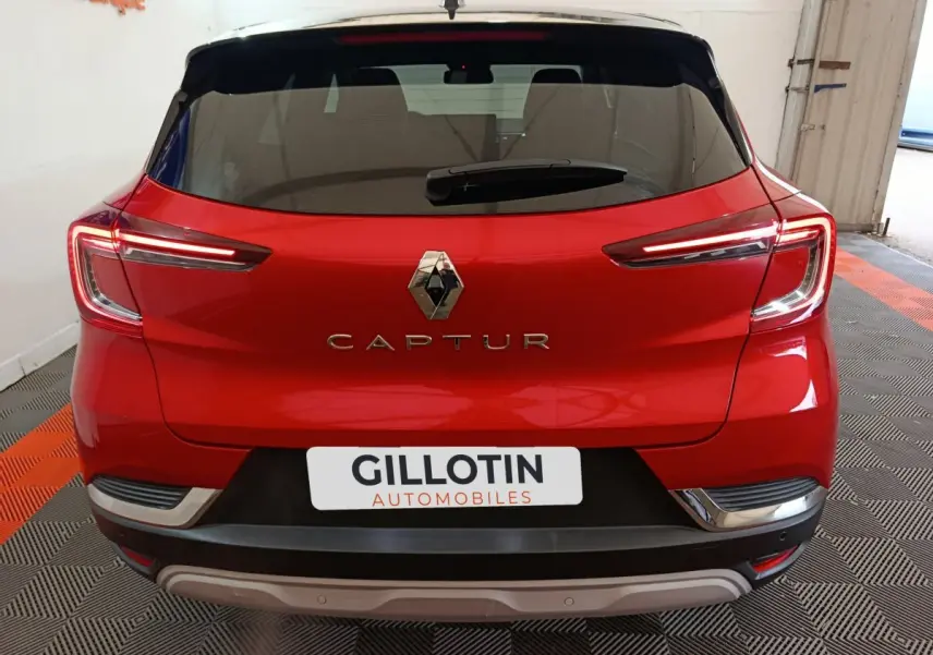 Vue arrière d'un Renault Captur rouge 2024 avec feux LED caractéristiques et logo central visible.