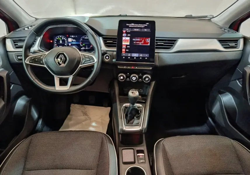 Intérieur Renault Captur 2024 vue avant, tableau de bord noir avec écran tactile vertical et boîte manuelle.