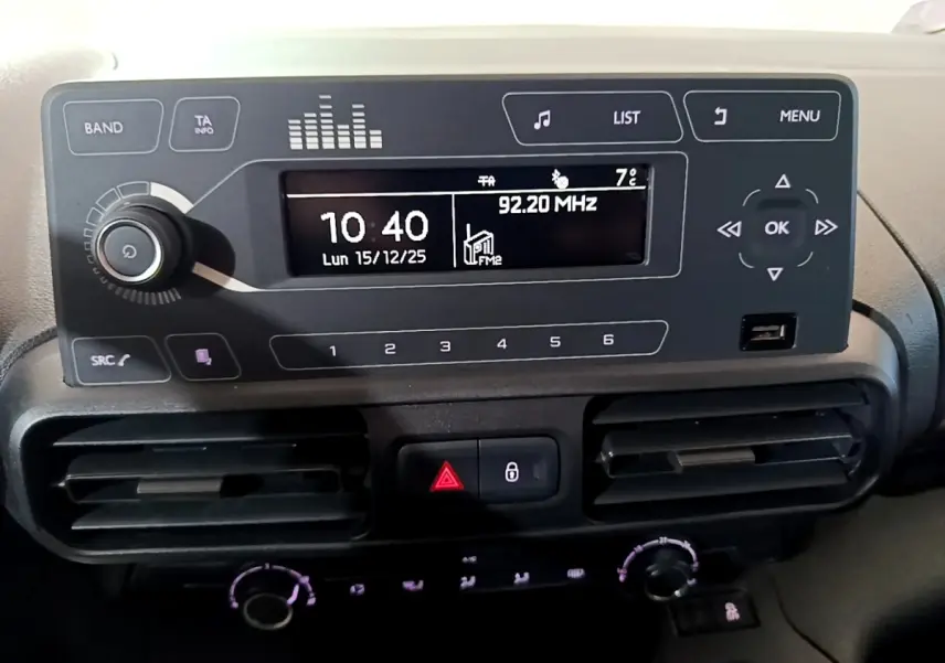 Vue rapprochée du tableau de bord noir du Citroën Berlingo XL blanc, affichant l’écran radio et les commandes climatisation.