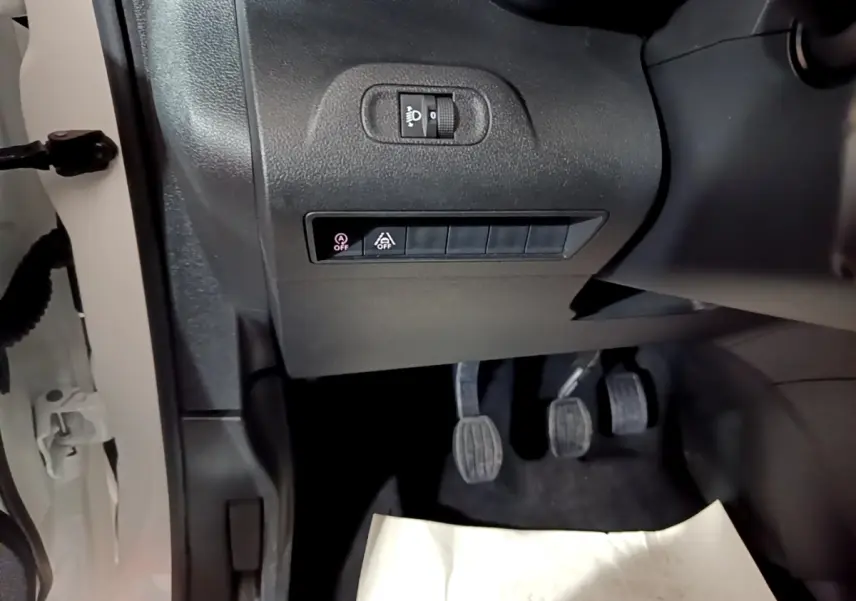 Vue intérieure côté conducteur du Citroën Berlingo blanc 2019, montrant les pédales et commandes sous le tableau de bord.