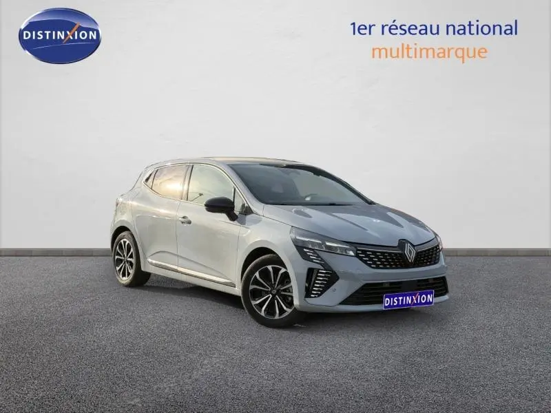 Renault Clio 1.6 E-Tech gris Rafale en 3/4 avant droit, avec calandre distinctive et jantes noires bicolores.