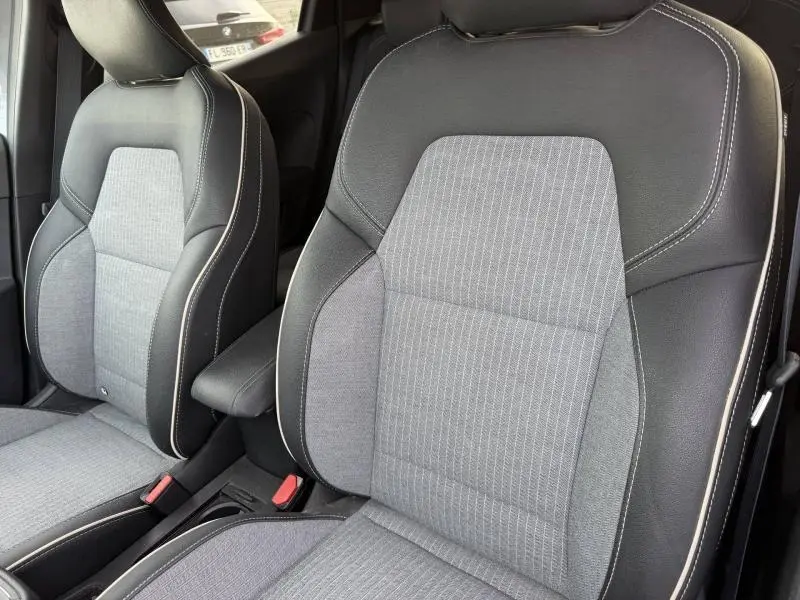 Gros plan sur les sièges avant gris clair et noir de la Renault Clio 1.6 E-Tech 145ch full hybrid Techno 2025.