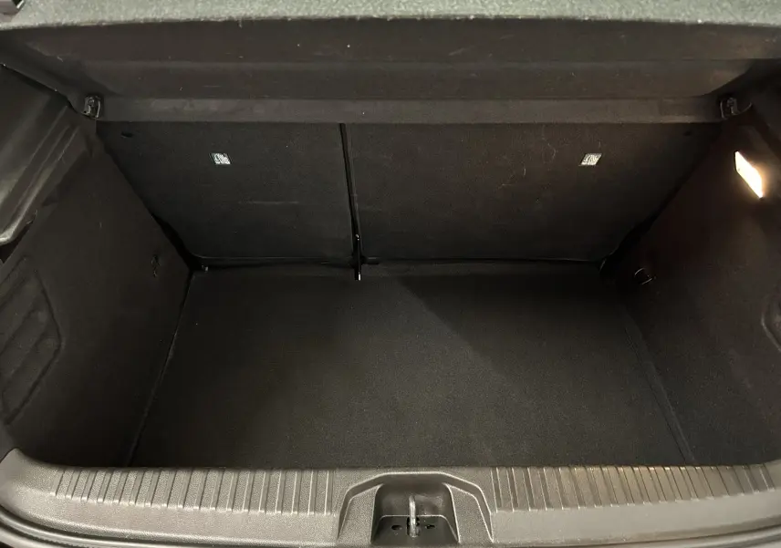 Coffre ouvert vu de face, intérieur noir propre et spacieux de la Renault Clio V BluedCi 100 Evolution 2025.