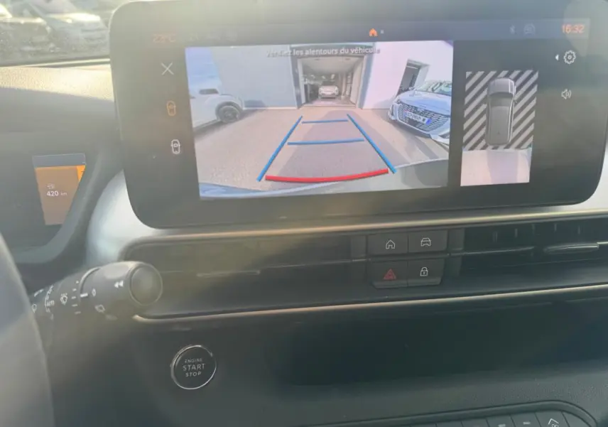 Vue intérieure du tableau de bord du Jeep Avenger gris 2025, avec écran tactile affichant la caméra de recul en marche.