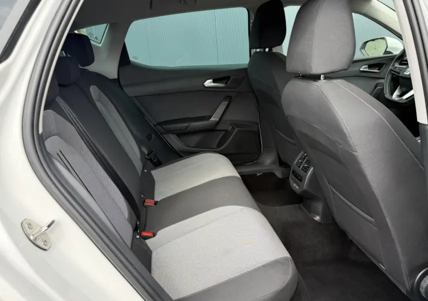 Vue intérieure côté gauche des sièges arrière gris et noirs d'une SEAT LEON blanche de 2025.