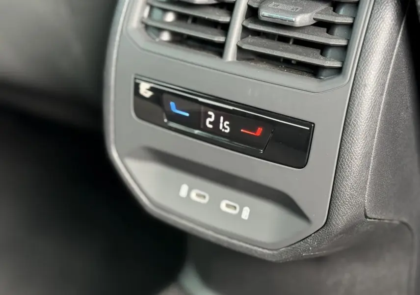 Détail du panneau de climatisation arrière avec affichage digital et prises USB-C dans une SEAT Leon blanche.