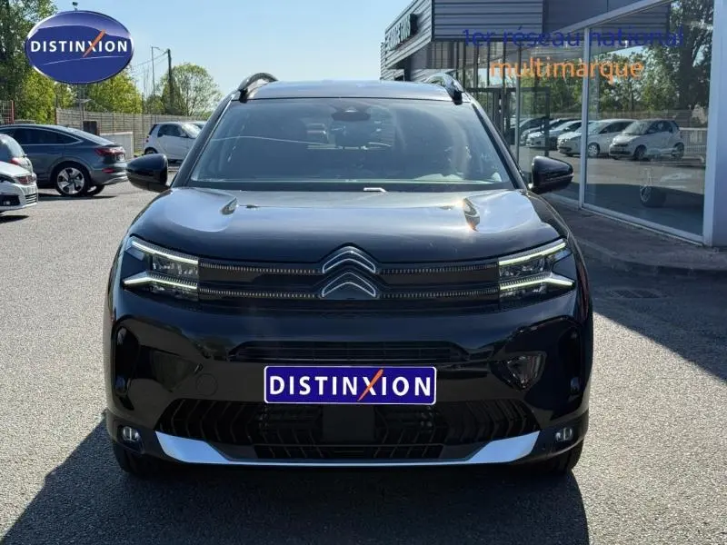 Vue de face du Citroën C5 Aircross noir Perla Nera avec calandre distinctive et phares LED fins allumés.
