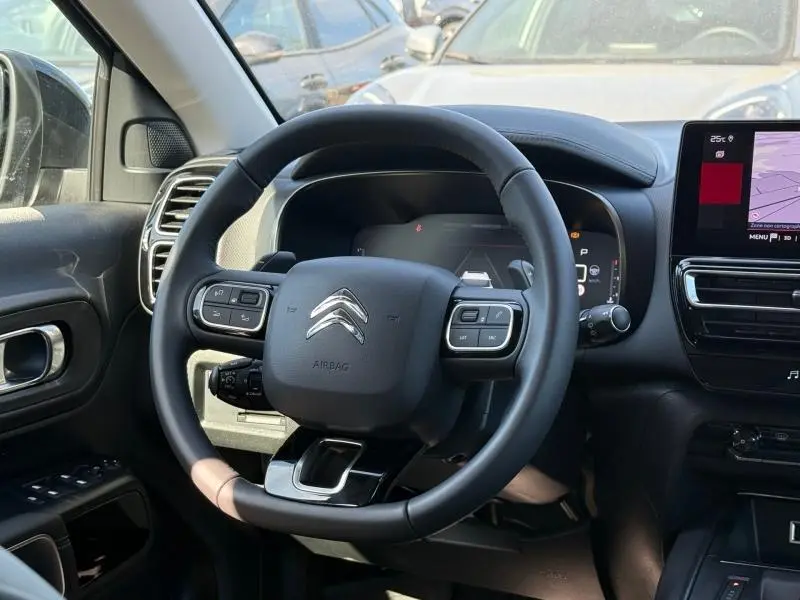 Vue intérieure centrée sur le volant cuir multifonction du Citroën C5 Aircross 2025 avec écran tactile et tableau de bord numérique.