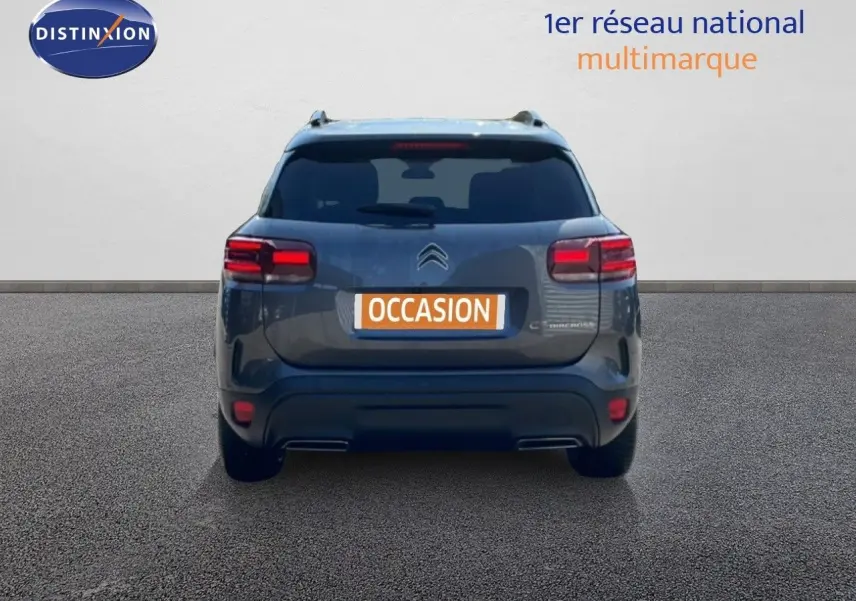 Vue arrière d'un Citroën C5 Aircross gris platinium métal avec feux arrière allumés sur fond neutre.