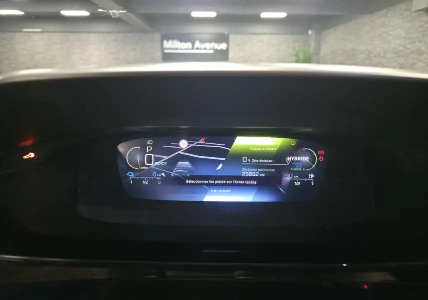 Affichage numérique du tableau de bord de la Peugeot 308 hybride rechargeable 2024, avec navigation et indicateurs de charge.