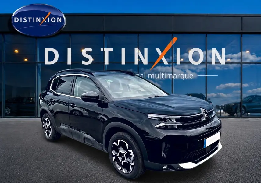 Citroën C5 Aircross noir vue 3/4 avant droit avec jantes alu et barres de toit devant vitrine Distinxion.