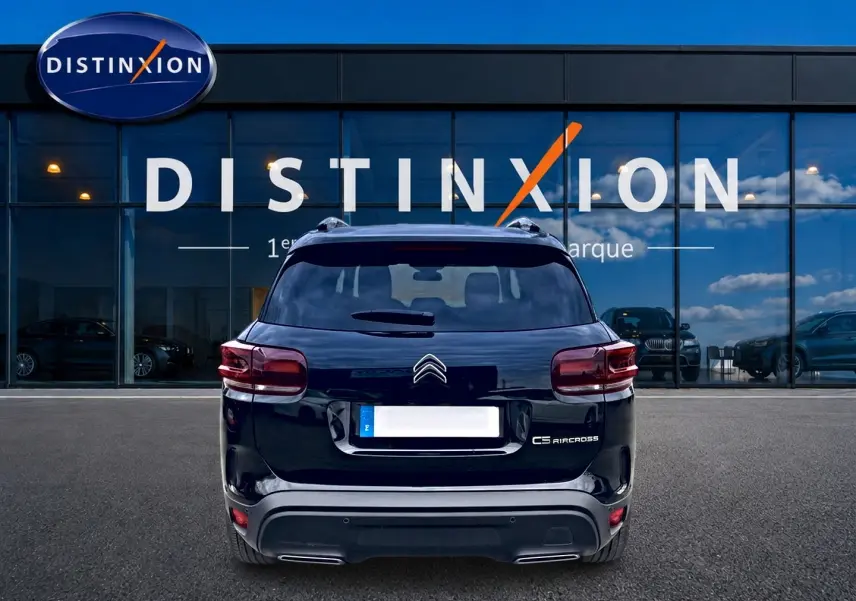 Vue arrière d'un Citroën C5 Aircross noir 2025 avec feux LED et barres de toit visibles devant une vitrine Distinxion.