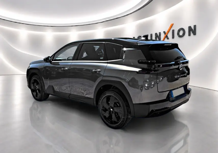 Vue 3/4 arrière droite d’un Citroën C5 Aircross gris platinium avec toit noir et jantes alliage noires.