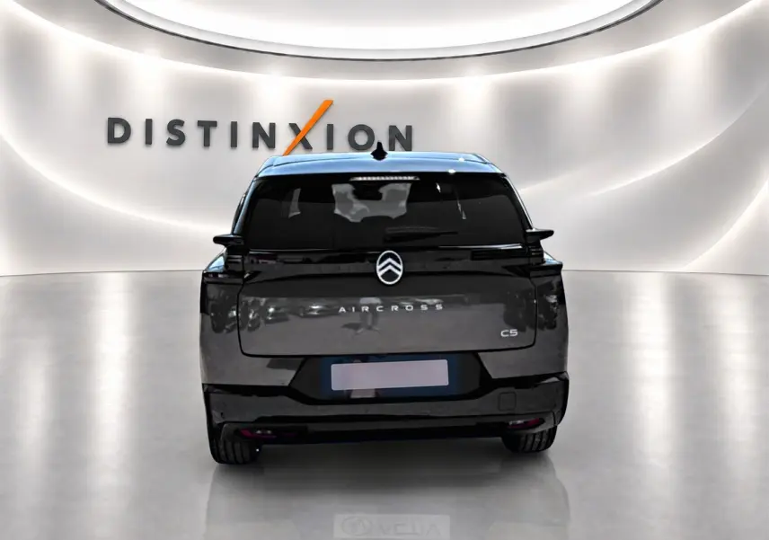 Vue arrière d’un Citroën C5 Aircross gris platinium avec toit noir, dans un showroom lumineux au logo Distinxion.