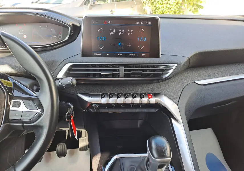Intérieur du Peugeot 3008 2019 vue du conducteur, tableau de bord avec écran tactile et levier de vitesses manuel noir.