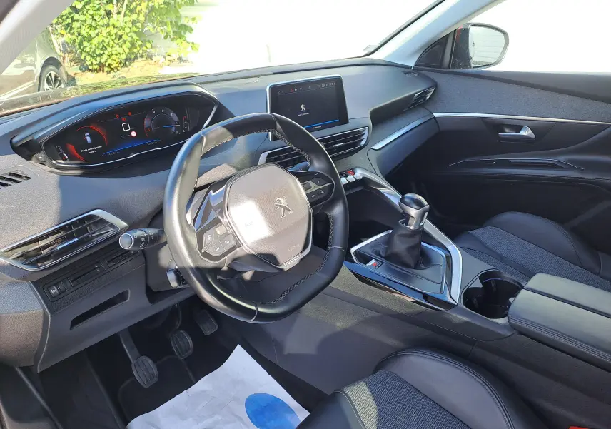 Vue intérieure côté conducteur du Peugeot 3008 2019 avec volant cuir noir et tableau de bord numérique moderne.