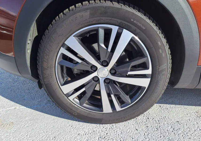 Gros plan sur la roue avant gauche du Peugeot 3008 2019 metallic cooper avec jante alliage bicolore et pneu Michelin.