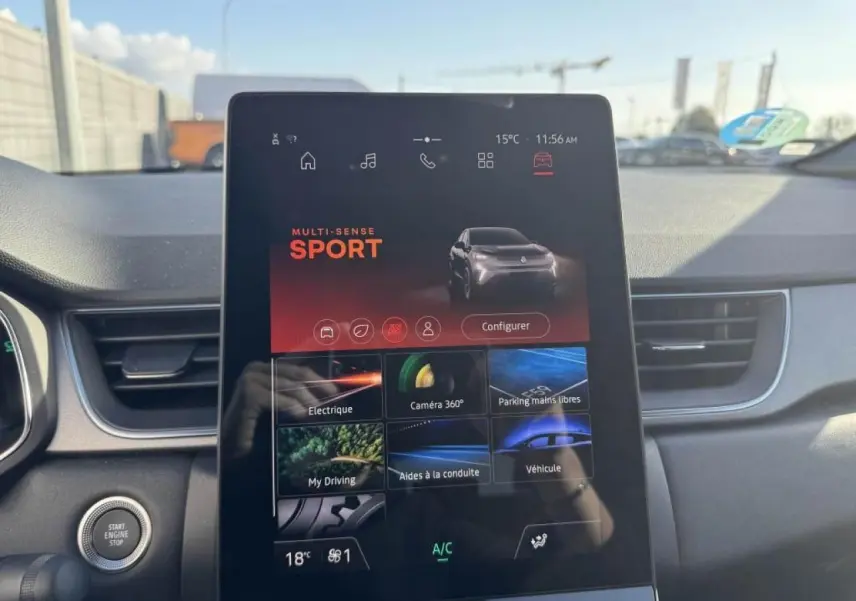 Vue intérieure centrée sur l'écran tactile du tableau de bord du Renault Captur gris Cassiopée, mode Sport affiché.