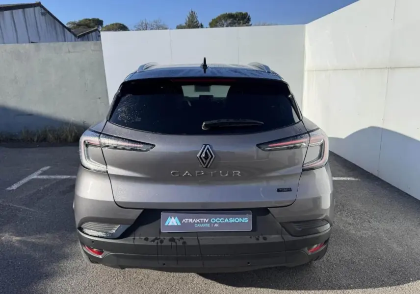 Vue arrière d'un Renault Captur gris Cassiopée avec toit noir, feux LED et logo bien visibles.