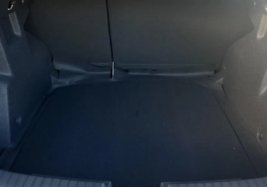 Coffre vide vu de face du Dacia Duster 2025, intérieur noir sans équipement visible.