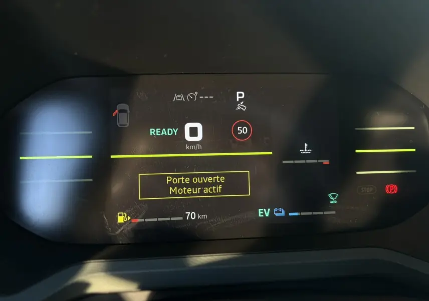 Affichage digital du tableau de bord du Dacia Duster 2025, indiquant porte ouverte et moteur actif.