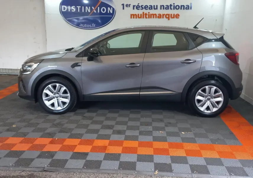 Profil droit d'un Renault Captur Business gris clair 2020, avec jantes alliage et rétroviseurs noirs dans un showroom.