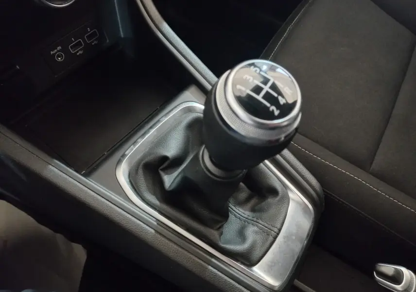 Le levier de vitesse manuel noir du Renault Captur Business TCe 100 2020, entouré de garnitures chromées et tissu noir.