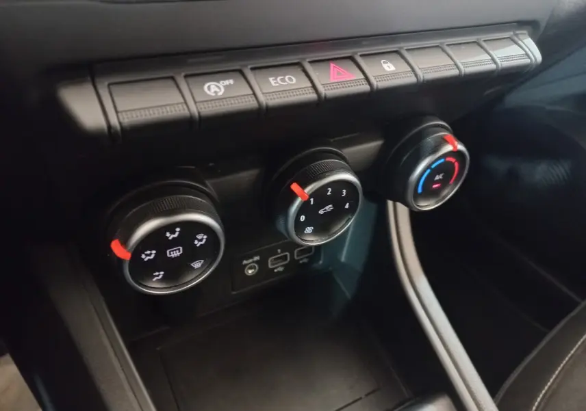 Gros plan sur les commandes de climatisation et boutons fonctionnels du tableau de bord du Renault Captur Business TCe 100 gris clair.