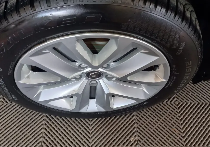 Gros plan sur la jante argentée avec logo Renault d'un Renault Captur gris clair, pneu Falken visible.