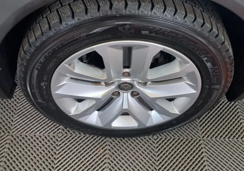 Gros plan sur la roue avant droite du Renault Captur Business gris clair avec jante alliage et pneu hiver