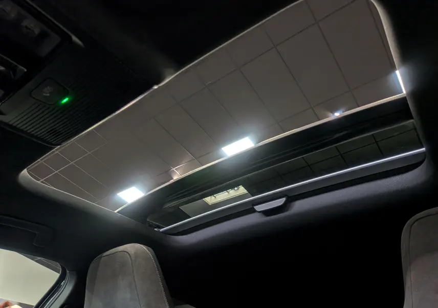 Toit ouvrant panoramique ouvert vu de l'intérieur d'une Volkswagen Golf gris dauphin, mettant en valeur les sièges avant.