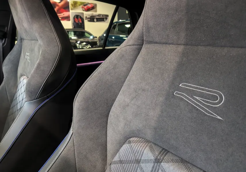 Gros plan sur les sièges avant en alcantara gris avec logo R brodé, intérieur de Volkswagen Golf 1.5 eTSI 2025.
