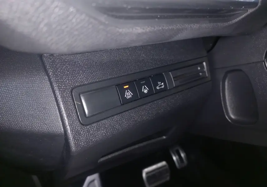 Gros plan sur les boutons de commande d'aide à la conduite dans l'habitacle noir du Peugeot 3008 GT gris clair.