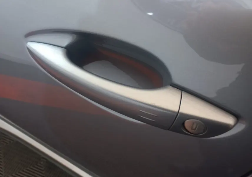 Poignée de porte avant droite gris clair sur Peugeot 3008 PureTech 130 S&S EAT8 GT 2022, détail extérieur.