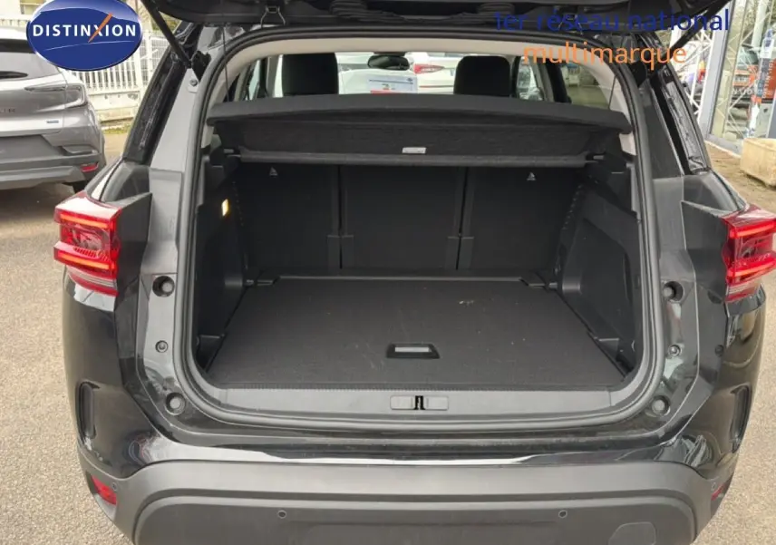 Coffre ouvert vu de l'arrière d'un Citroën C5 Aircross noir métal 2025, montrant un espace de chargement vide.