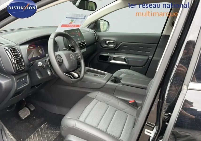 Vue intérieure côté conducteur du Citroën C5 Aircross noir métal 2025, avec tableau de bord et sièges en tissu et cuir.