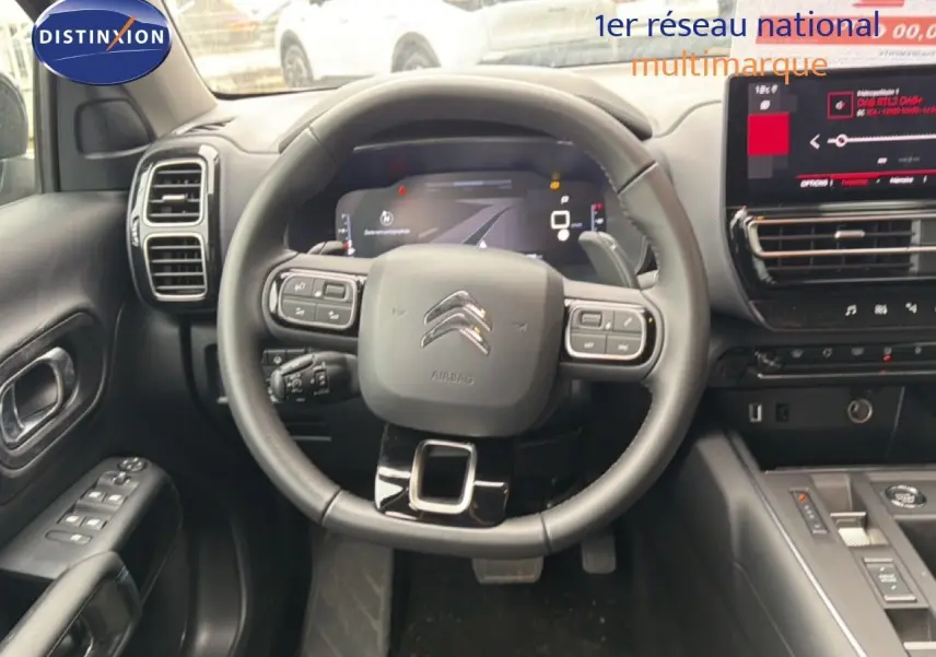 Vue intérieure centrée sur le volant multifonction et tableau de bord numérique du Citroën C5 Aircross noir métal 2025.