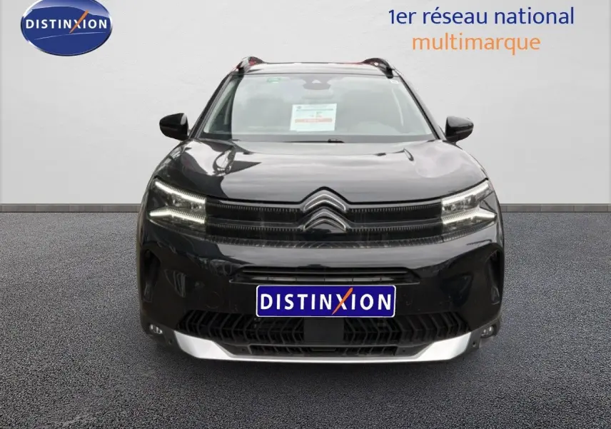 Vue frontale d'un Citroën C5 Aircross noir métal 2025 avec calandre distinctive et phares LED allumés.