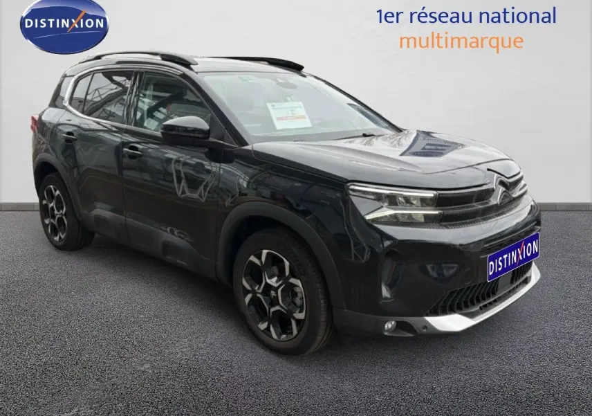 Citroën C5 Aircross noir métal en 3/4 avant droit, avec jantes distinctives et barres de toit visibles.