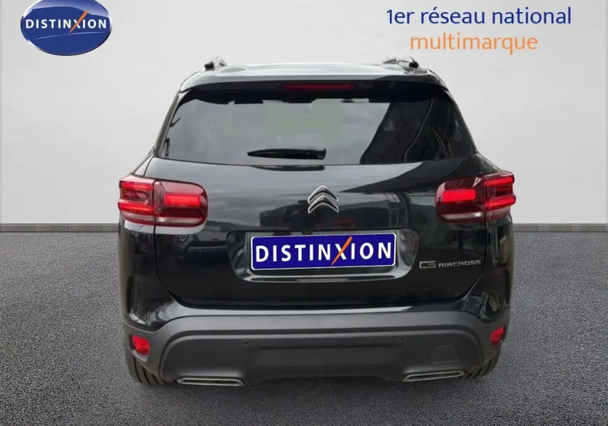 Vue arrière d'un Citroën C5 Aircross noir métal 2025 avec feux arrière allumés et double sortie d'échappement.