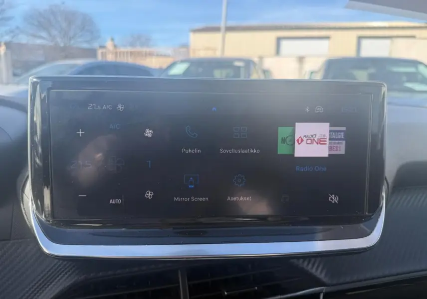 Écran tactile du tableau de bord du Peugeot 208 Hybrid blanc, affichant les réglages climatisation et multimédia.