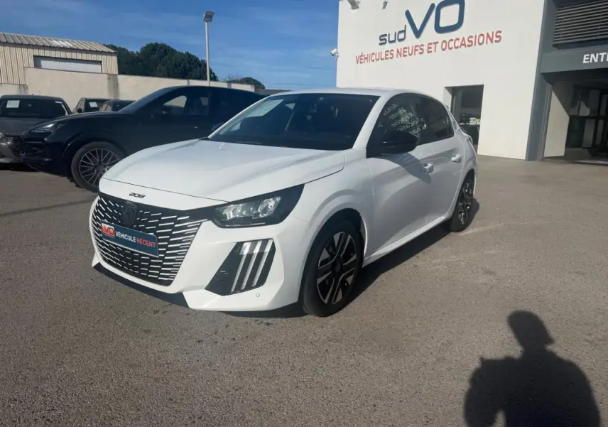 PEUGEOT 208 Hybrid blanc vue 3/4 avant droit, calandre distinctive et jantes noires, stationné devant un concessionnaire.