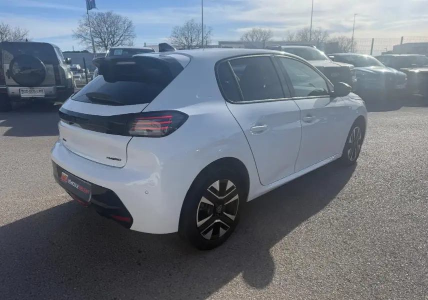 Vue 3/4 arrière droite d'une Peugeot 208 Hybrid 110 e-DCS6 Allure blanche avec feux arrière sombres et jantes stylisées.