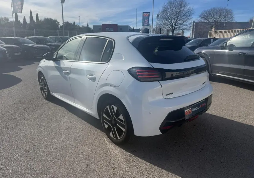 Peugeot 208 Hybrid blanc vue 3/4 arrière droit, feux arrière LED et jantes alliage distinctives visibles.