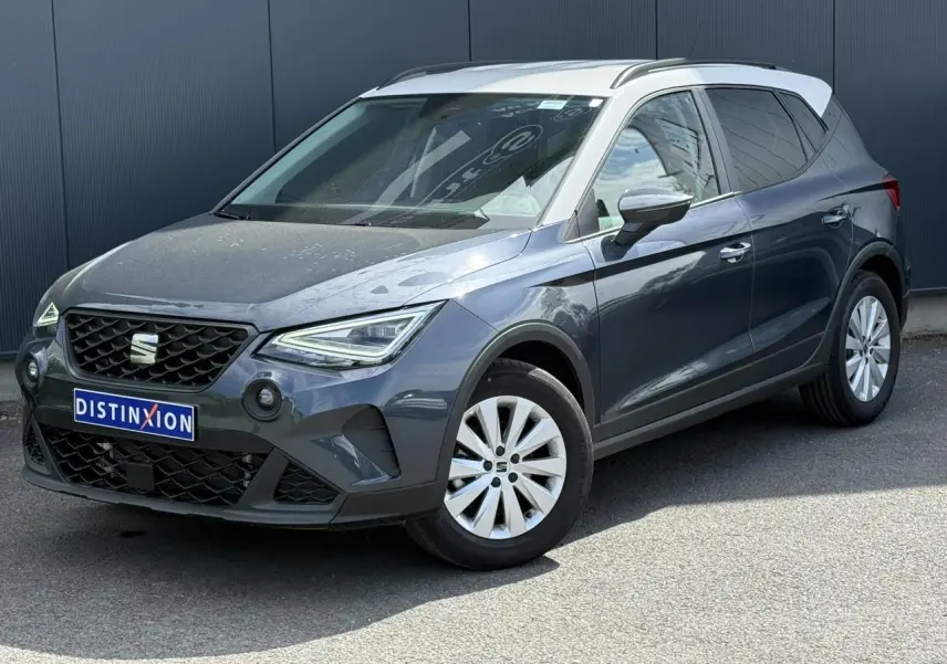 SEAT Arona TSI 115 Style 2025 en gris magnétique avec toit blanc, vue 3/4 avant droit sur fond urbain.
