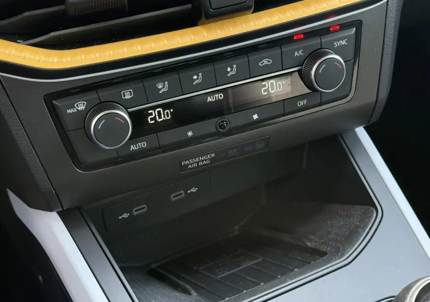 Gros plan sur la console centrale du SEAT Arona 2025, montrant la climatisation automatique bi-zone et ports USB.