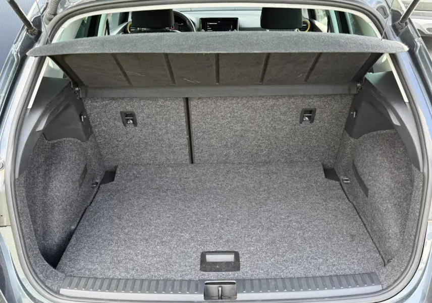 Coffre ouvert du SEAT Arona gris magnétique, vue arrière montrant l’espace de chargement et la tablette cache-bagages.